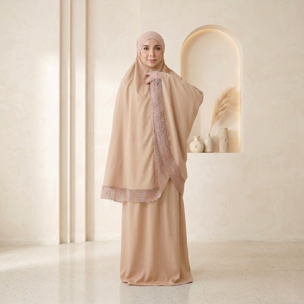 Woman wearing a beige abaya with lace details in a minimalistic setting